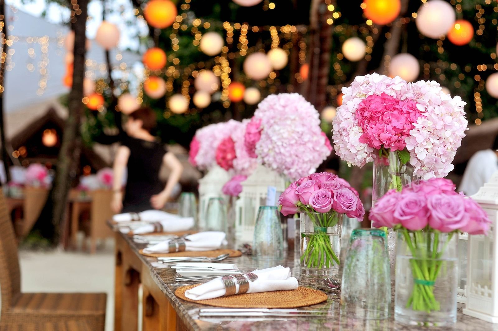 A long table set for a celebration beneath trees
